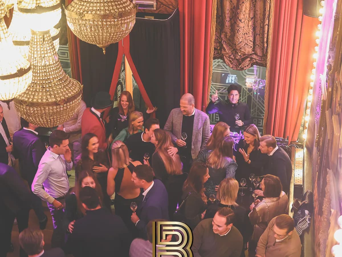 Gasten genieten van een feest met champagne onder de kroonluchters in Bar Boudoir