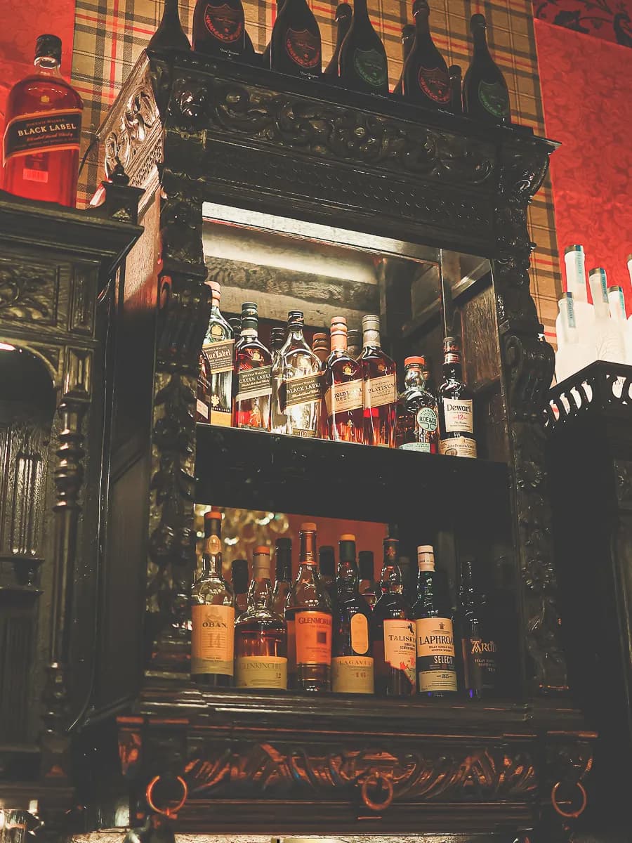 Whiskeyselectie op een antieke houten bar in Bar Boudoir