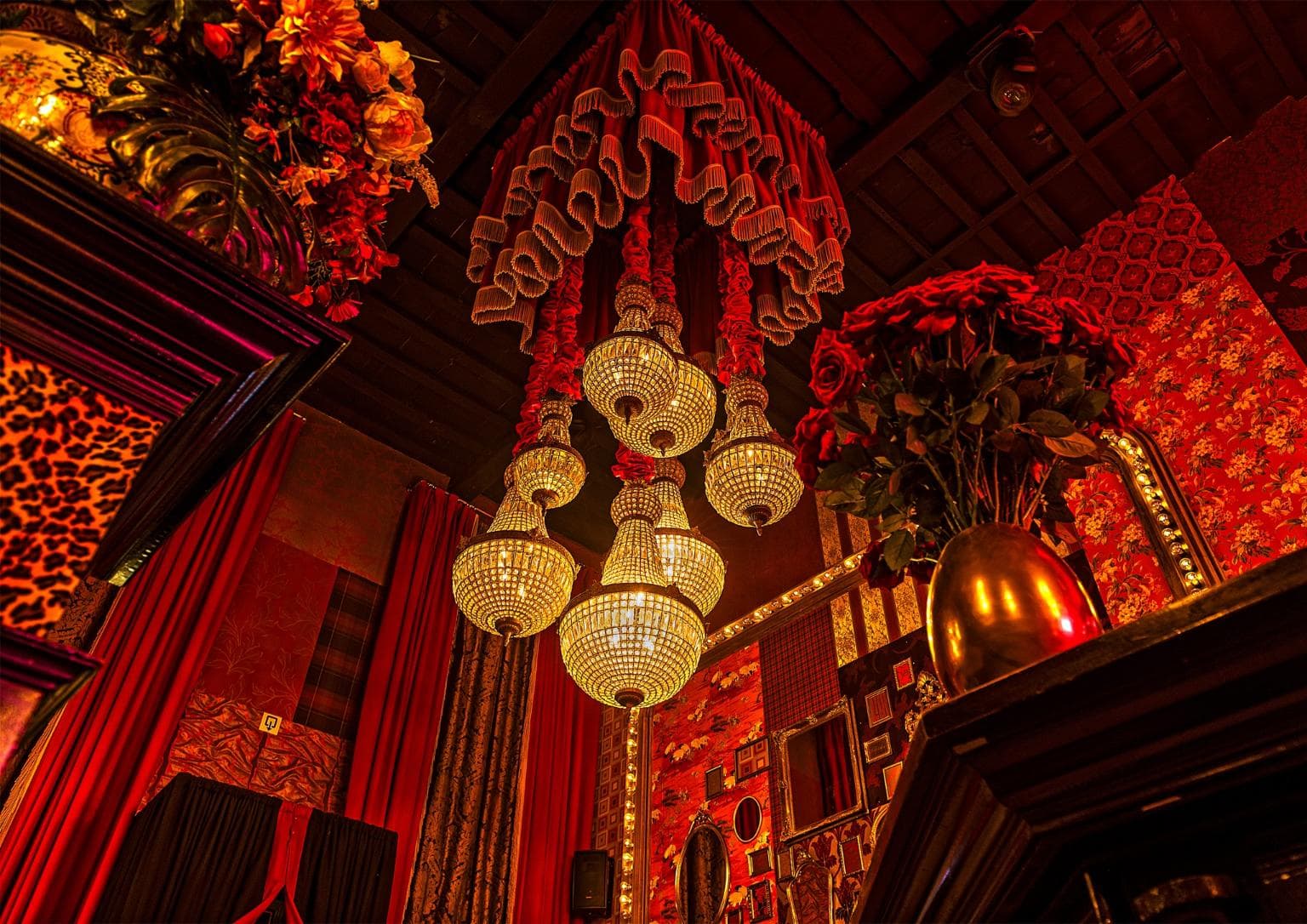Bar Boudoir interieur met kroonluchters en rode bloemen